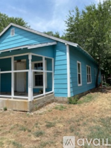 A blue house with a porch and a white door.