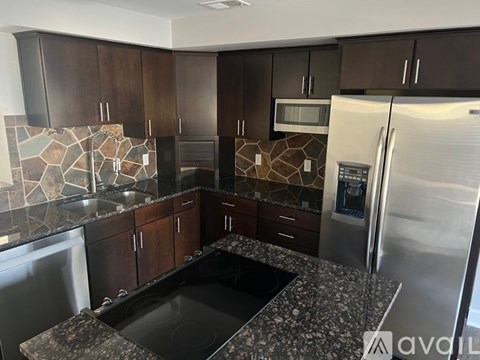 A kitchen with a black granite countertop and stainless steel appliances.