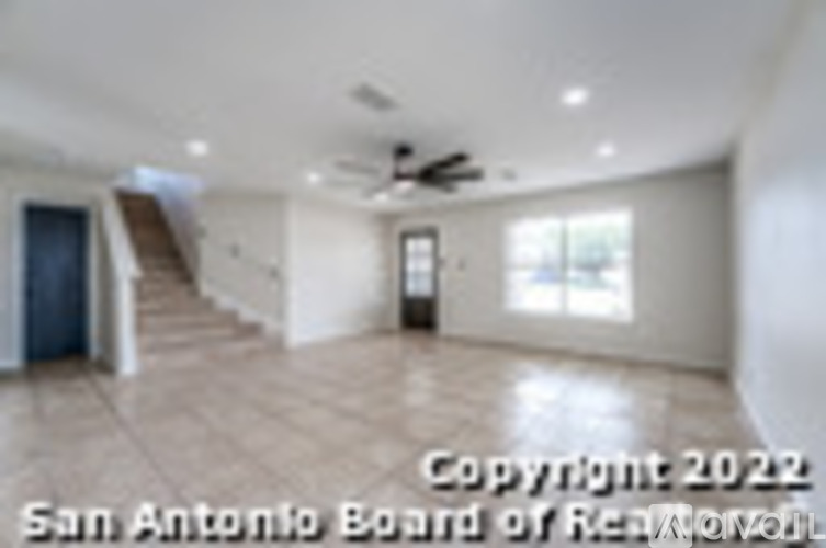 A spacious room with a staircase and a door leading to another room.