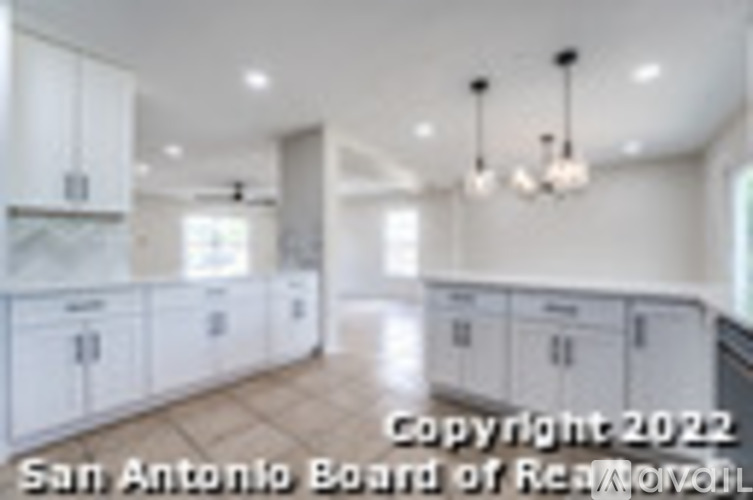A kitchen with white cabinets and a wooden floor.