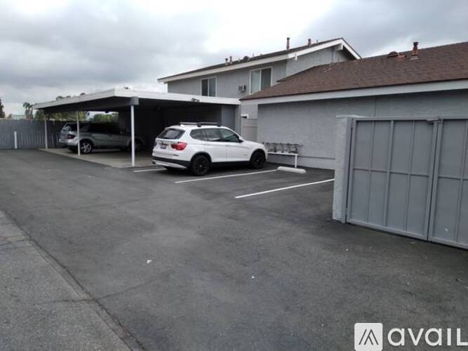 A car is parked in a parking lot with a building in the background.