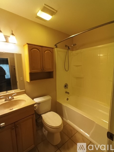 A bathroom with a toilet, sink, and bathtub.