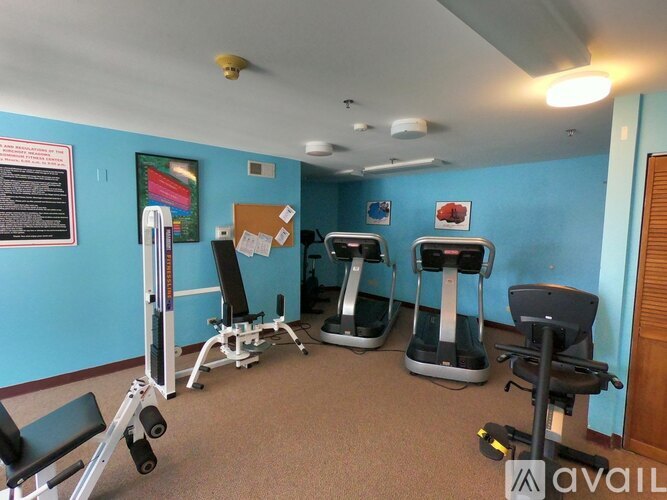 A gym room with exercise equipment and a blue wall.