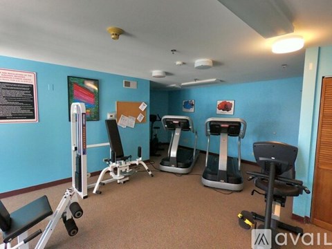 A gym room with exercise equipment and a blue wall.