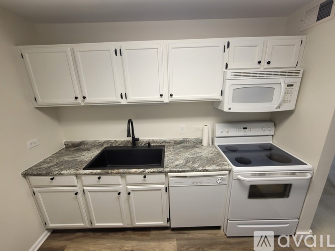 A kitchen with white cabinets and a granite countertop.