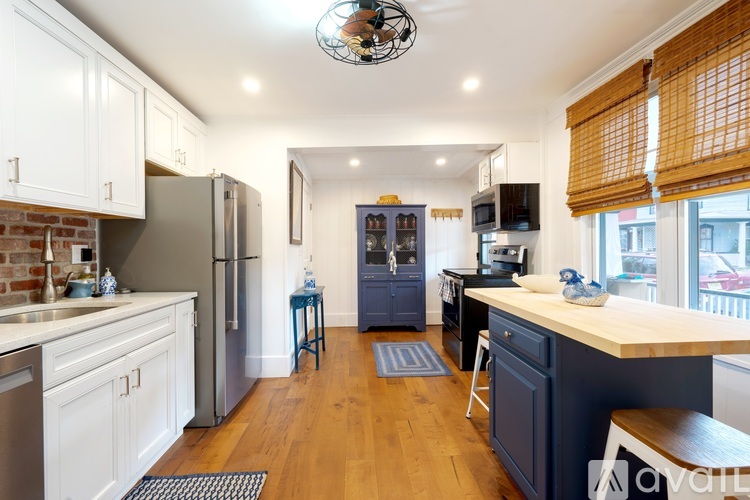 A kitchen with white cabinets and a wooden floor.