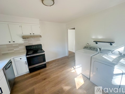 A kitchen with white cabinets and a black stove top oven.