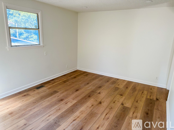 A room with wooden flooring and a window.