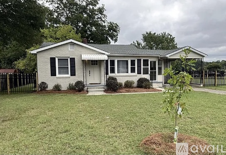 A house with a white front porch and black shutters.