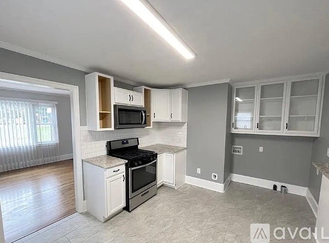 A kitchen with white appliances and cabinets.