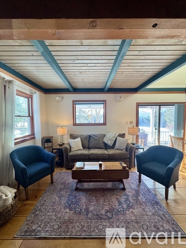 A living room with a couch, two chairs, and a coffee table.