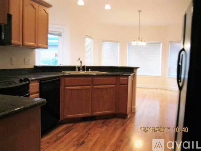 A kitchen with wooden cabinets and black appliances.