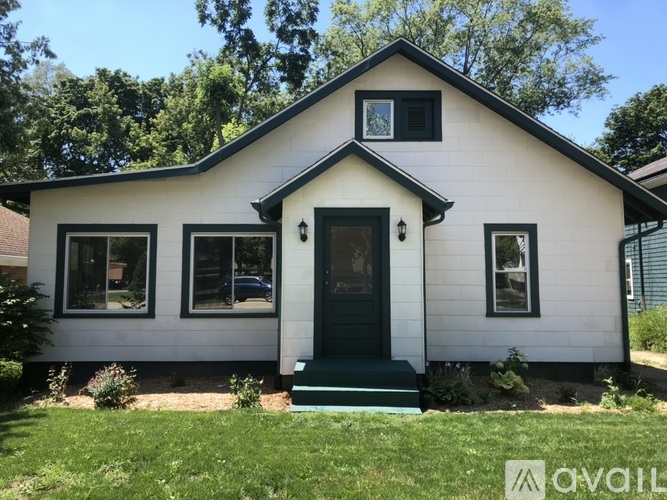 A white house with a black front door and windows.