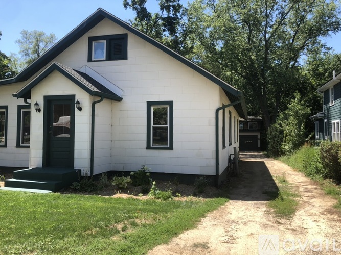 A small white house with a black door and windows.