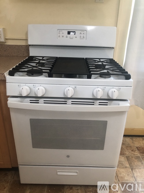 A white oven with a black stove top is in a kitchen.