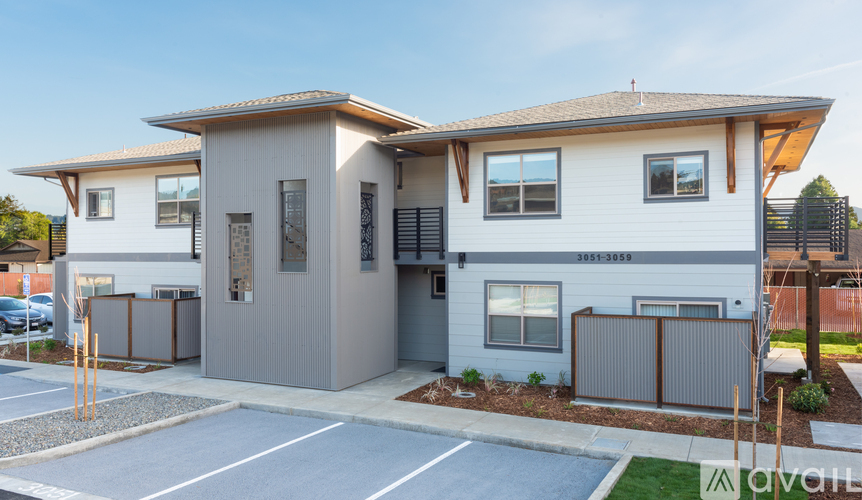 A modern two-story house with a garage and a driveway in front.