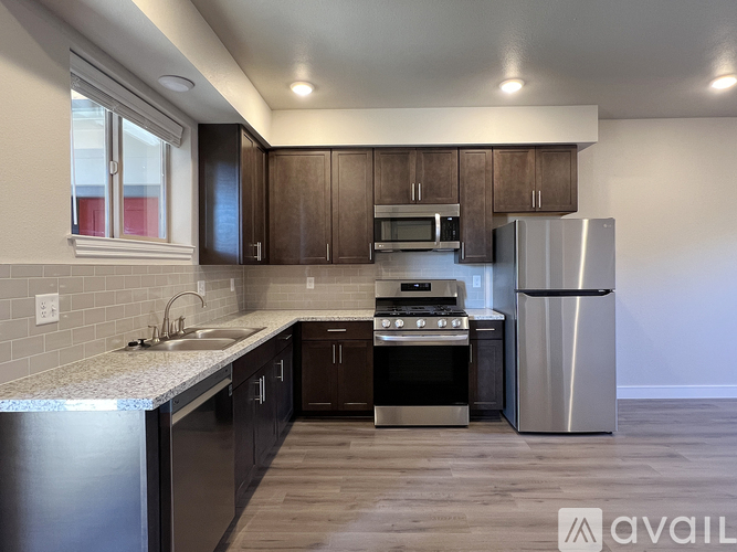 A kitchen with stainless steel appliances and wooden cabinets.