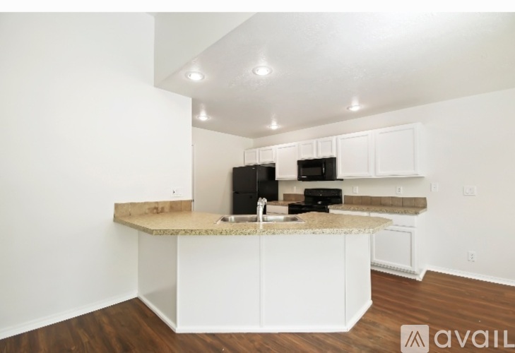 A kitchen with white cabinets and a countertop is available for rent.