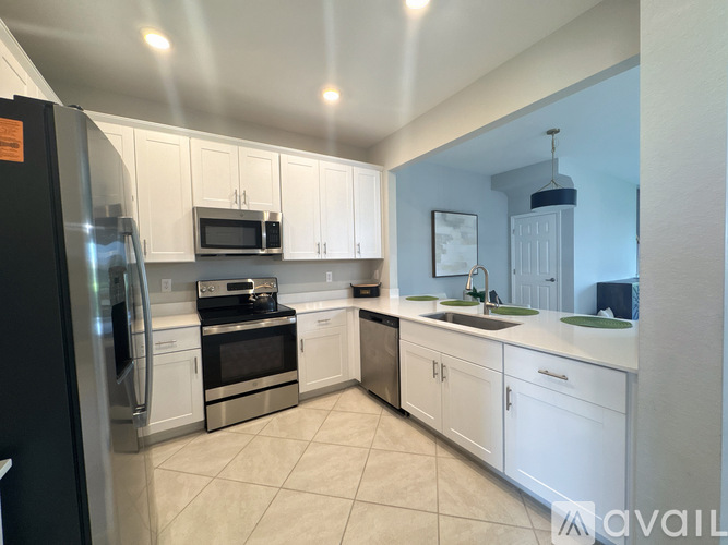 A kitchen with white cabinets and appliances.