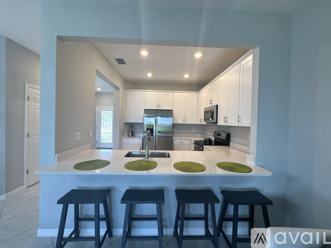 A kitchen with a bar area and stools.