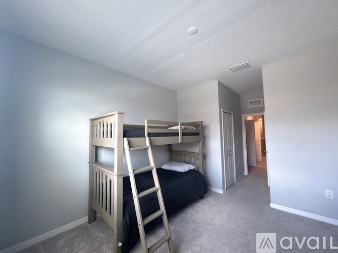 A bedroom with a bunk bed and a ladder.