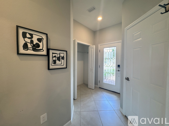 A hallway with two pictures on the wall and a door on the right.
