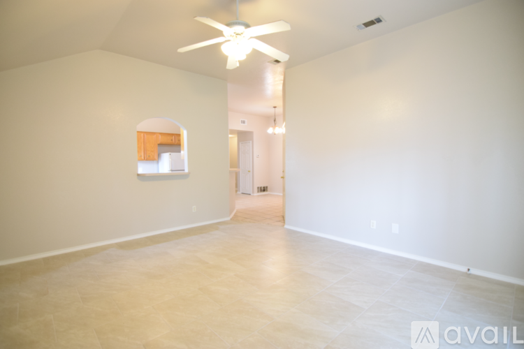A spacious room with a ceiling fan and a painting on the wall.