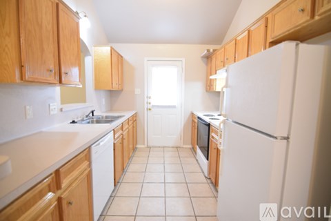 A kitchen with wooden cabinets and white appliances.