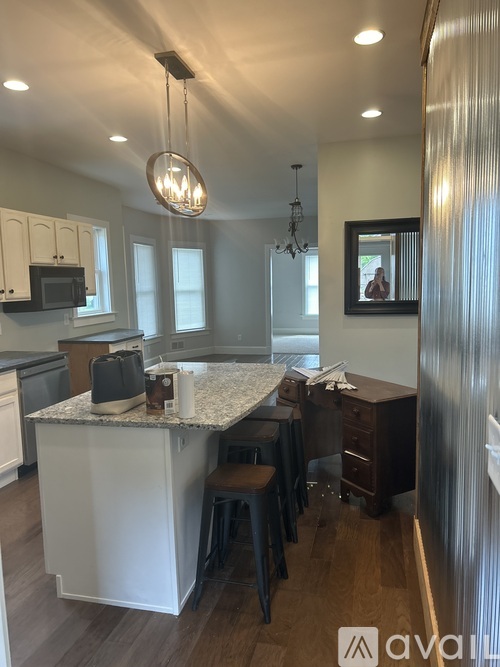 A kitchen with a granite countertop and a chandelier hanging from the ceiling.