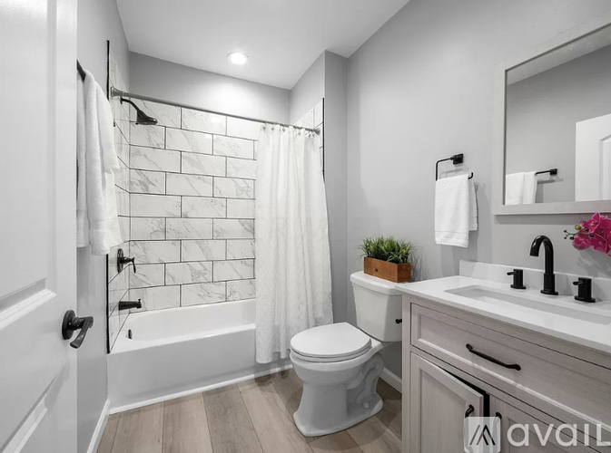 A bathroom with a white toilet, sink, and bathtub.
