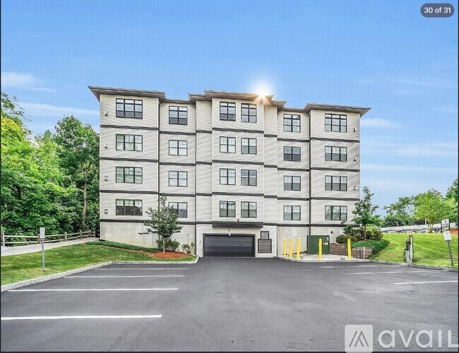 A modern apartment building with a parking lot in front.