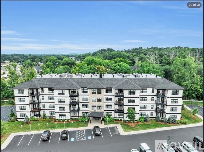 A large white building with a parking lot in front.