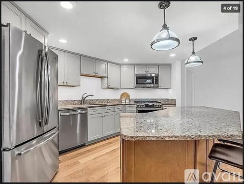 A modern kitchen with a stainless steel refrigerator and wooden cabinets.