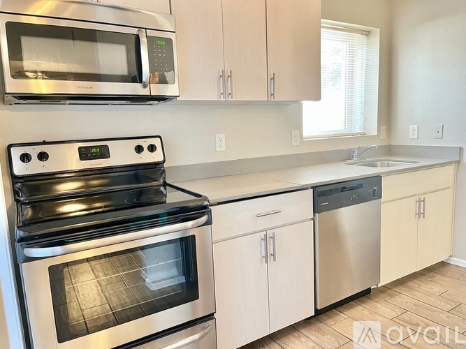 A modern kitchen with stainless steel appliances and white cabinets.