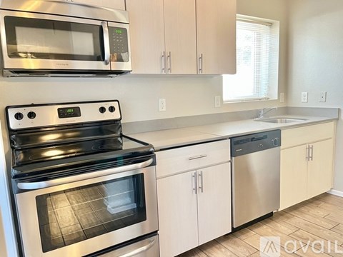 A modern kitchen with stainless steel appliances and white cabinets.