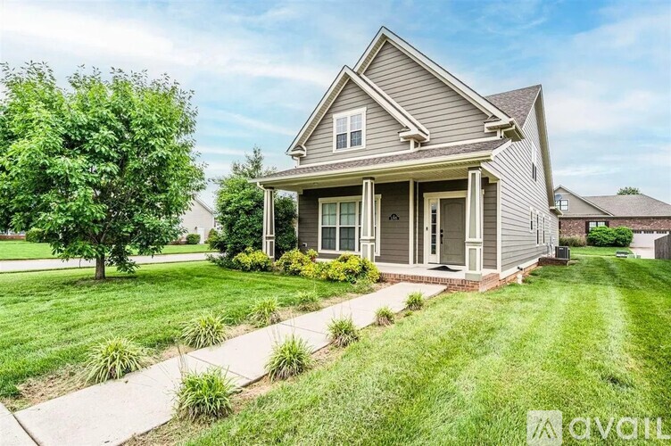 A house with a well-maintained lawn and a clear sky.