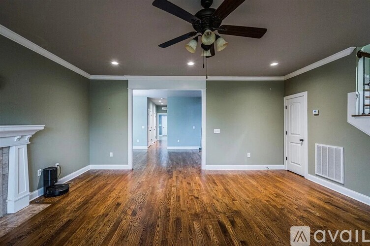 A spacious room with a fireplace and hardwood floors.