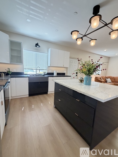 A modern kitchen with a large island and a dining area.