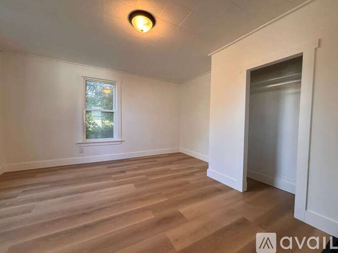 A room with wooden flooring and a window.