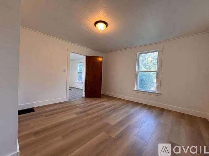A room with wooden flooring and a window.