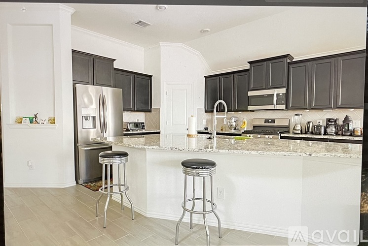 A kitchen with a white counter top and black cabinets.