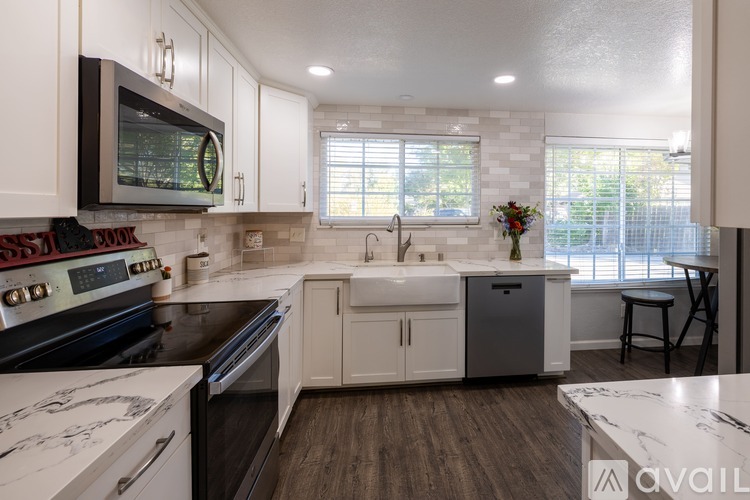 A kitchen with a black stove top oven and white cabinets.