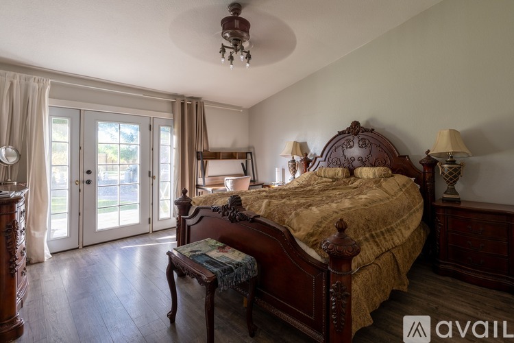 A bedroom with a large bed and a chandelier.