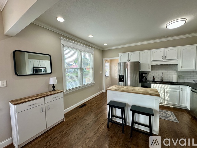 A kitchen with white cabinets and a wooden countertop.