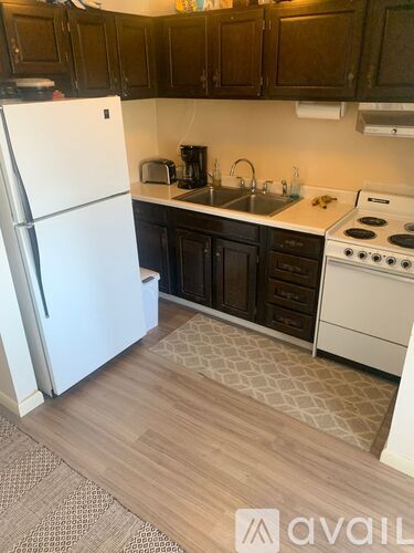 A kitchen with a white fridge and a white stove.
