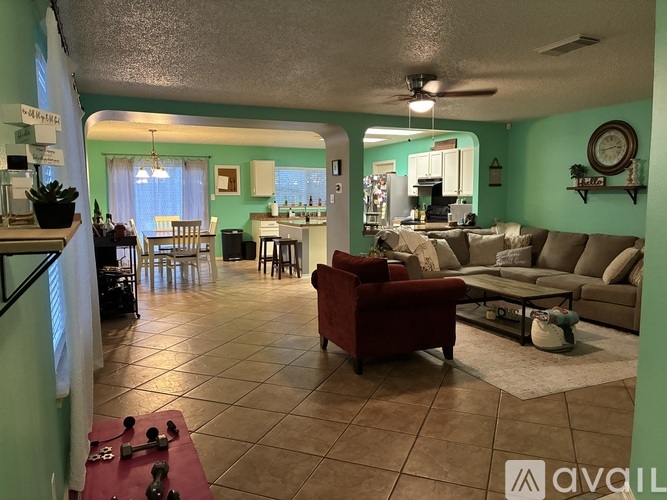 A living room with a red couch and a dining area with a table and chairs.
