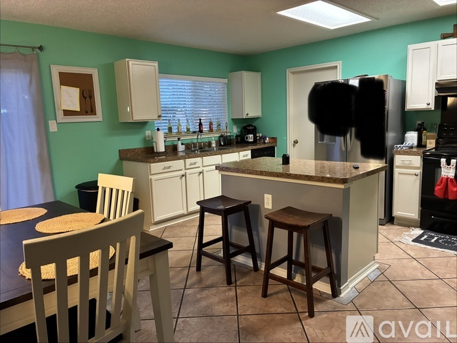 A kitchen with a table and chairs in front of it.