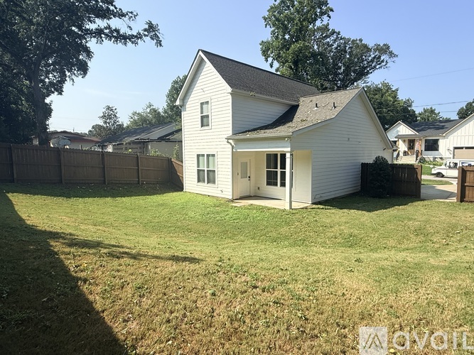 A white house with a brown fence in the front yard.