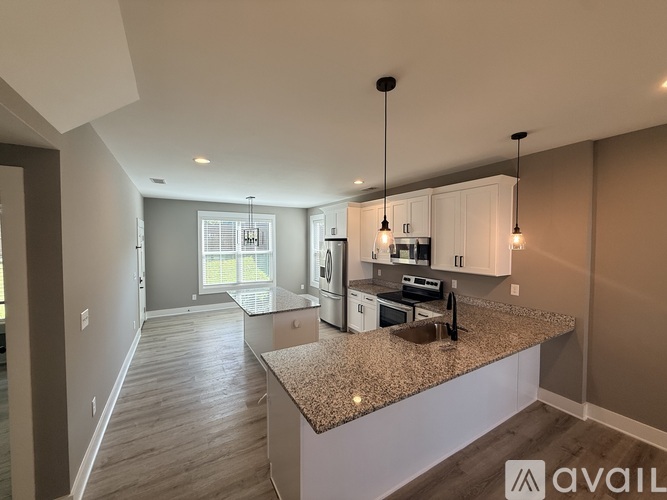 A kitchen with granite countertops and white cabinets.