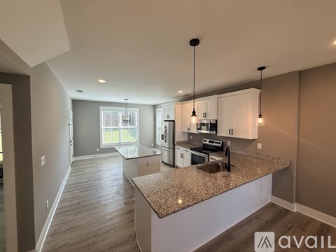 A kitchen with granite countertops and white cabinets.